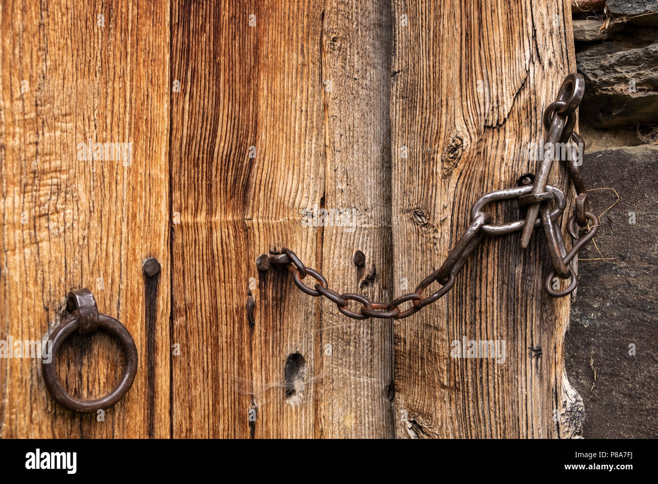Dettaglio close up della maniglia della porta e il lucchetto della catena su una vecchia fattoria in Liebro, Catalogna, Spagna Foto Stock