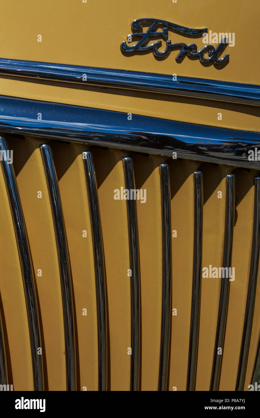 Stretto di close-up di classica vecchia Ford griglia anteriore che mostra il cromo, old Ford logo e vibrante vernice gialla lavoro. Foto Stock