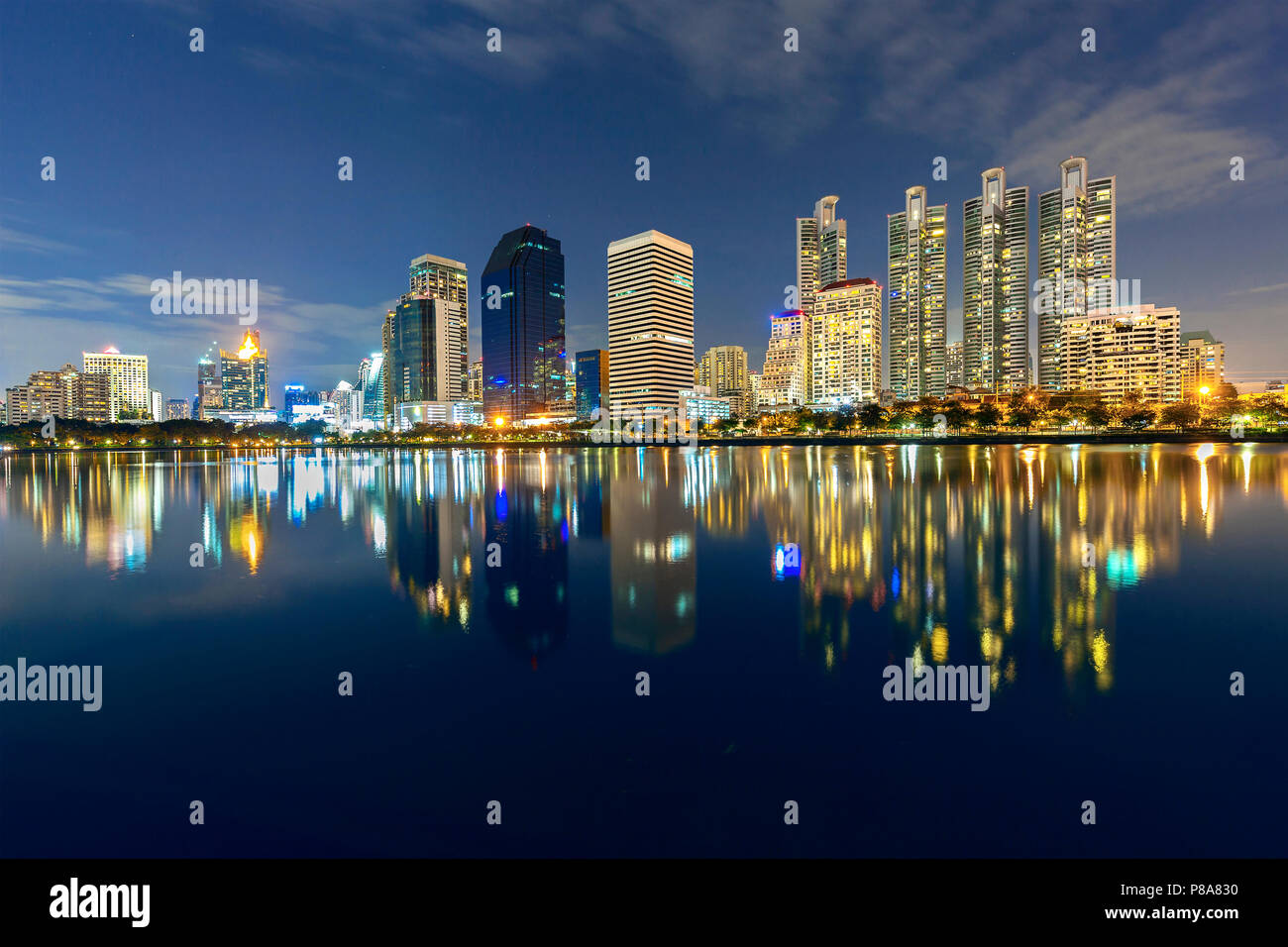 Skyline di Bangkok con riflessi nel lago, al crepuscolo, Thailandia Foto Stock