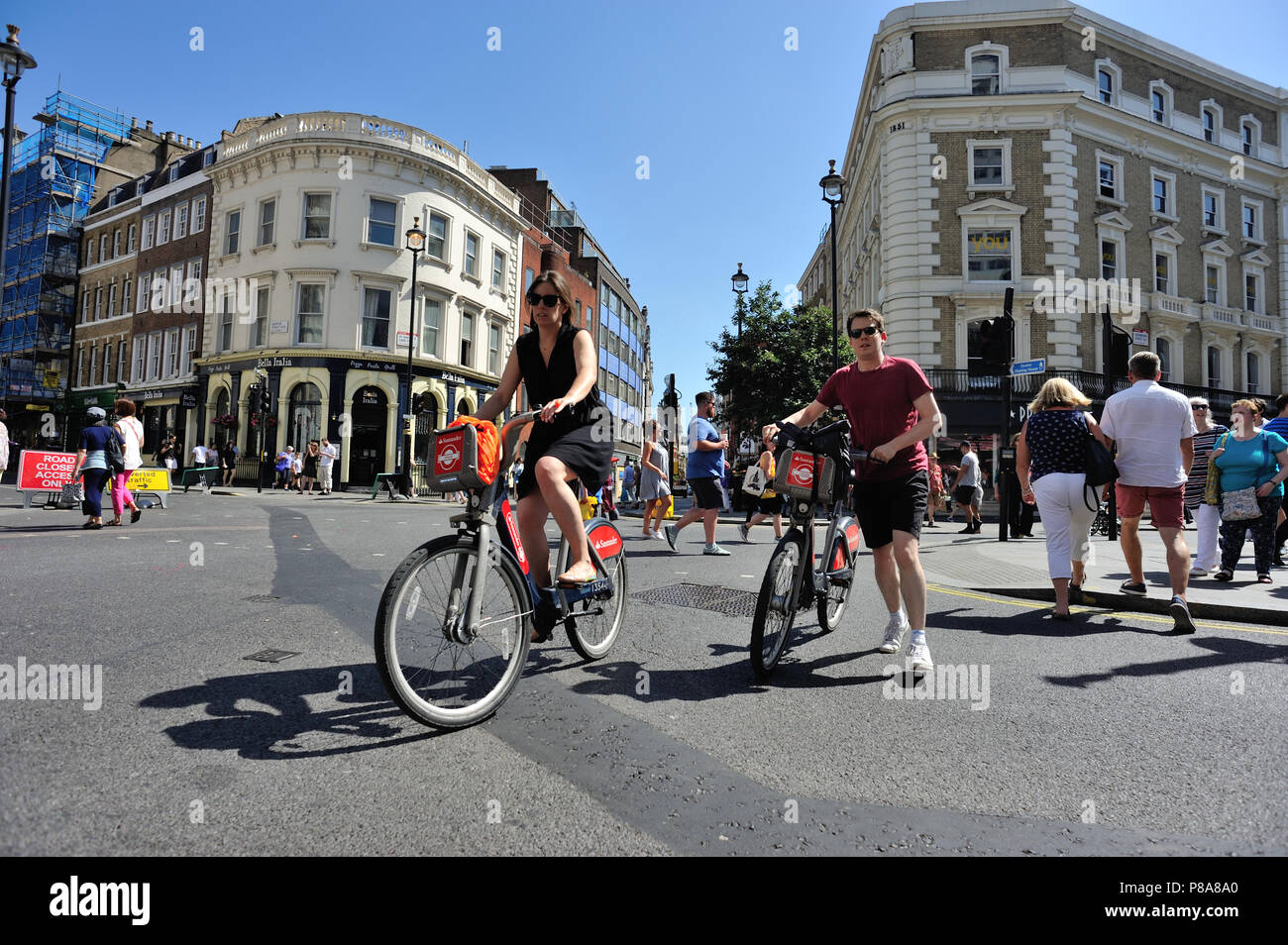 I ciclisti su strada di attraversamento, Cambridge Circus, London, England, Regno Unito Foto Stock