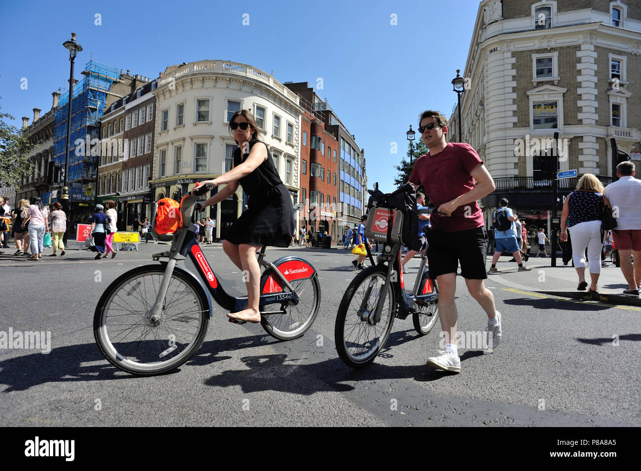 I ciclisti su strada di attraversamento, Cambridge Circus, London, England, Regno Unito Foto Stock