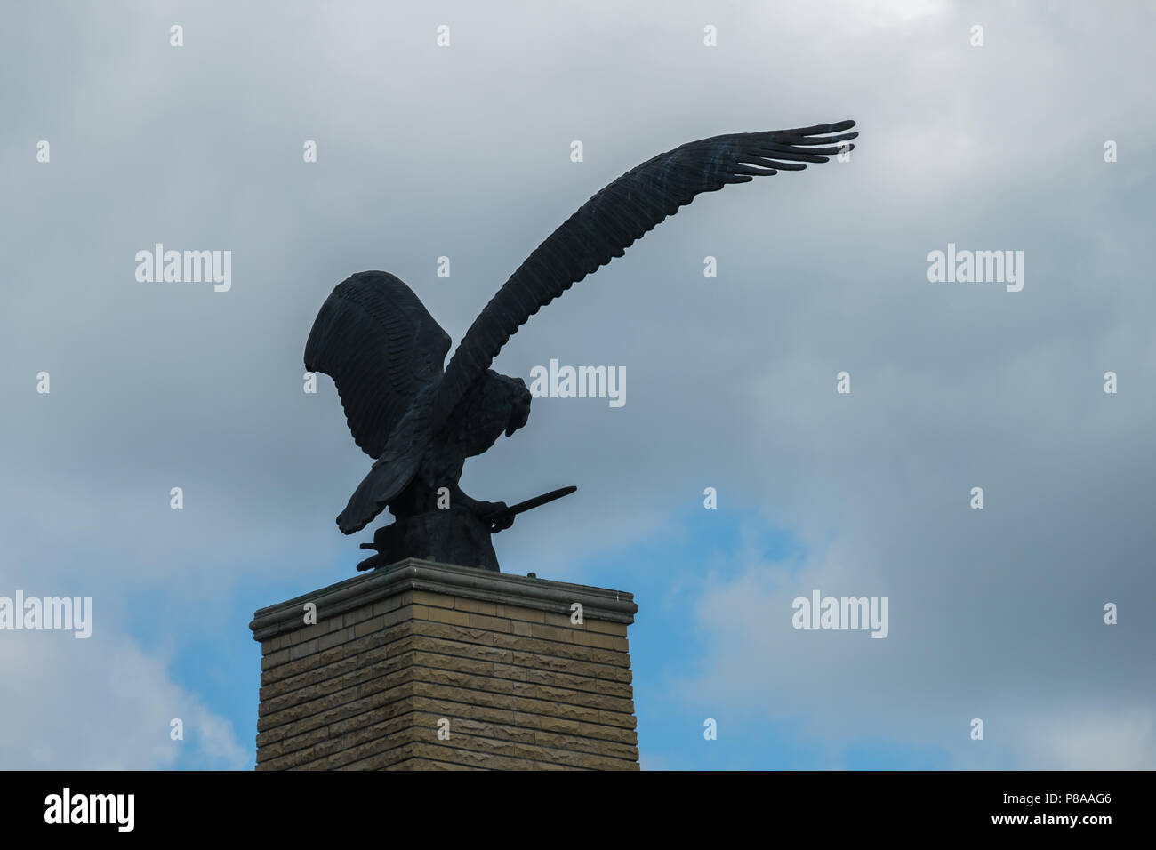 Statua di aquila con ali aperte contro un nuvoloso cielo nuvoloso . Per il vostro design Foto Stock