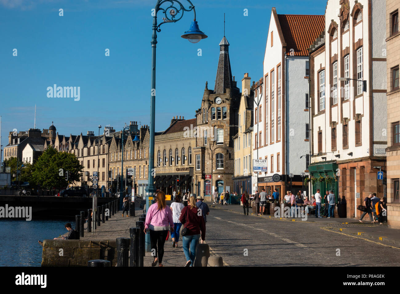 Di sera il sole estivo sulla riva accanto all'acqua di Leith in Leith, Edimburgo, Scozia, Regno Unito Foto Stock