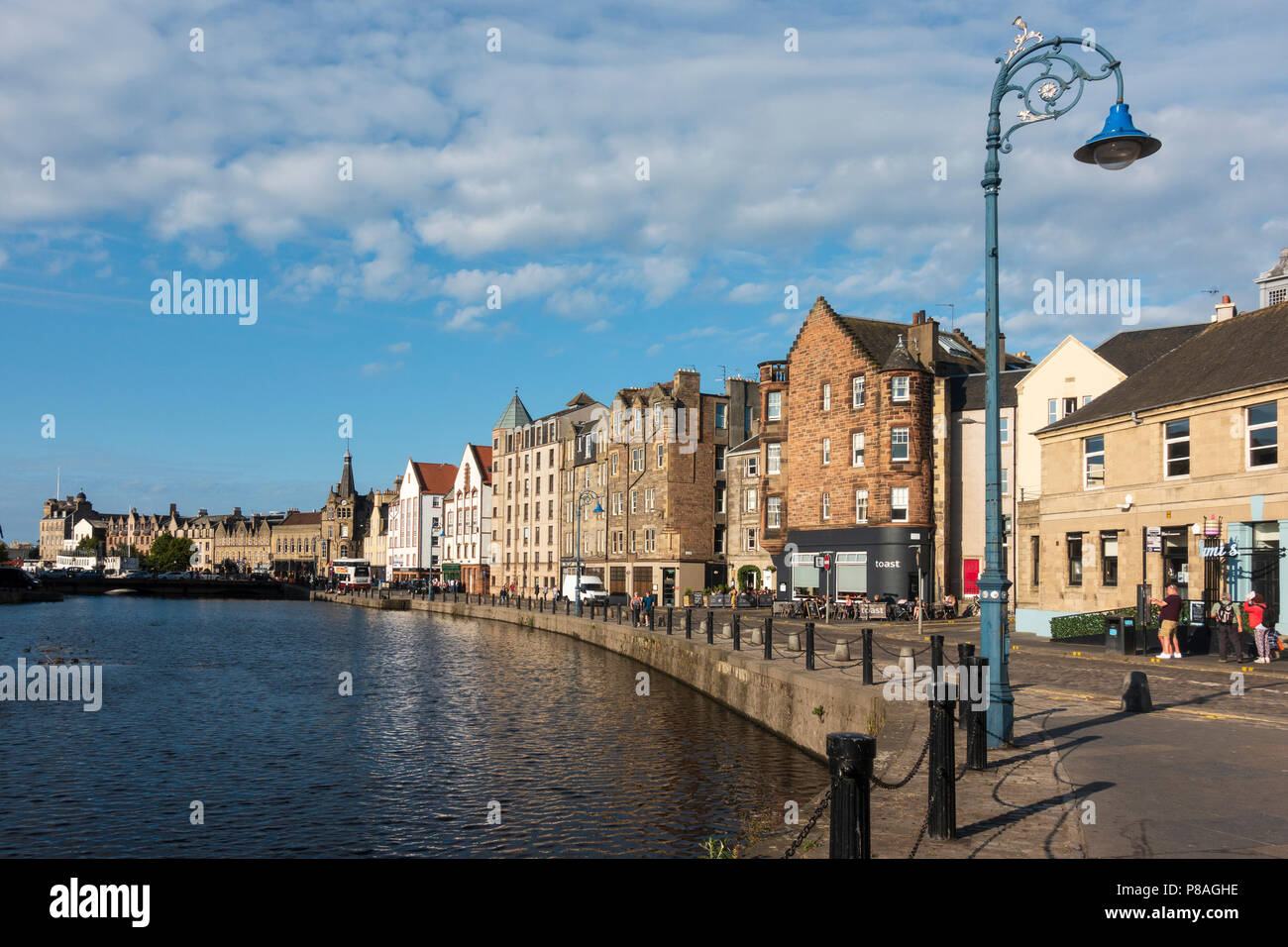 Di sera il sole estivo sulla riva accanto all'acqua di Leith in Leith, Edimburgo, Scozia, Regno Unito Foto Stock