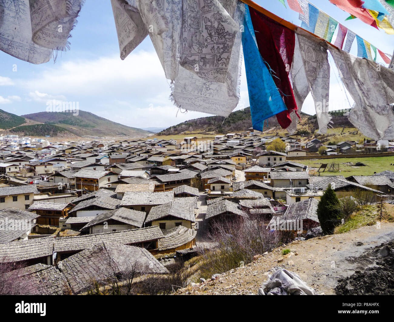 Guardando verso il basso sulla città vecchia di Zhongdian in Shangri-La, Cina, dall'alto della collina sacra con la preghiera le bandiere Foto Stock