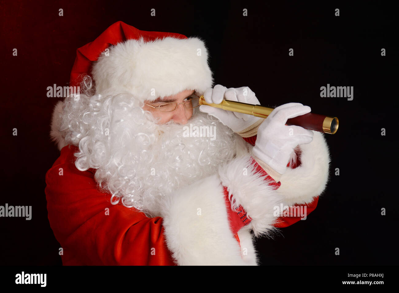 Santa Claus tenendo il cannocchiale, cercando qualcosa Foto Stock