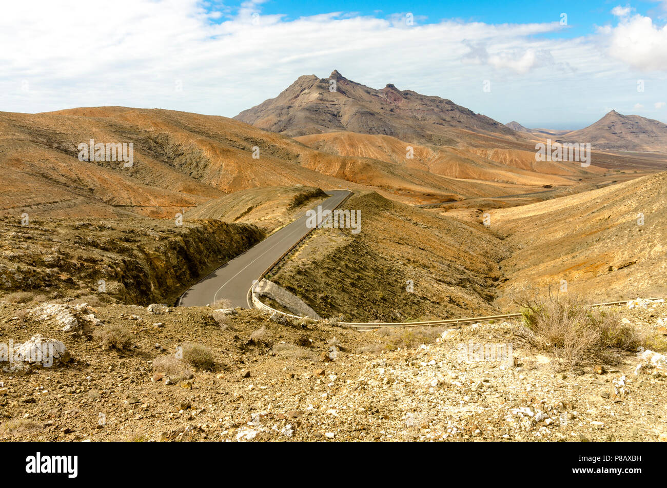 Tipico paesaggio di Fuerteventura con aride montagne vulcaniche e strade tortuose Foto Stock