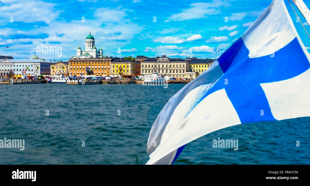 Skyline di Helsinki dal mare. La bandiera finlandese galleggia. Piazza del mercato e la Cattedrale di Helsinki dal mare. Il mare di Helsinki in estate. Foto Stock