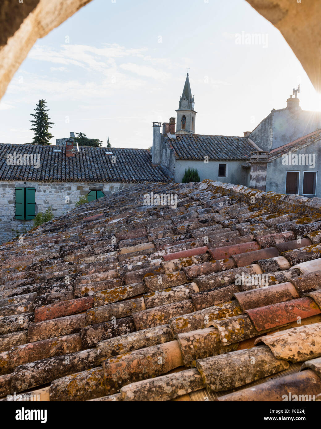 Tegole di terracotta e la guglia della chiesa al tramonto, Francia meridionale Foto Stock
