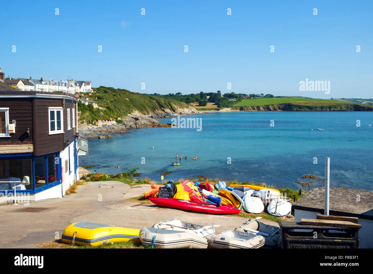Vista del porto e del litorale a Portscatho, Cornwall, Regno Unito su una bella mattina d'estate. Portscatho è una famiglia di famose località meta di vacanza. Foto Stock