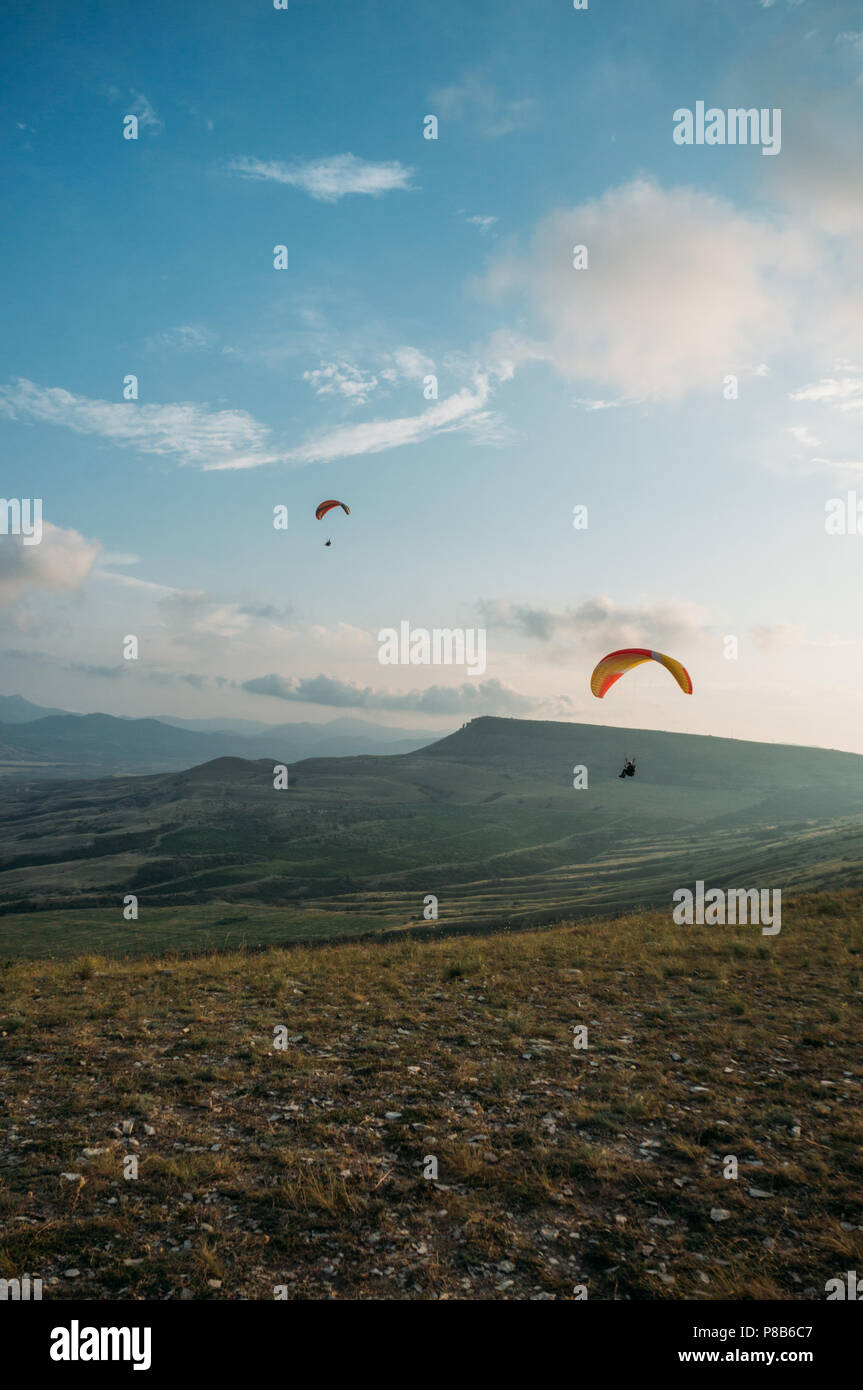 Paesaggio di montagna con i paracadutisti volare nel cielo, Crimea, Ucraina, Maggio 2013 Foto Stock