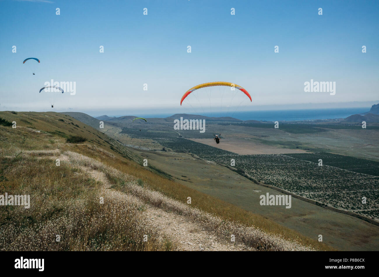 Paesaggio di montagna con i paracadutisti volare nel cielo, Crimea, Ucraina, Maggio 2013 Foto Stock