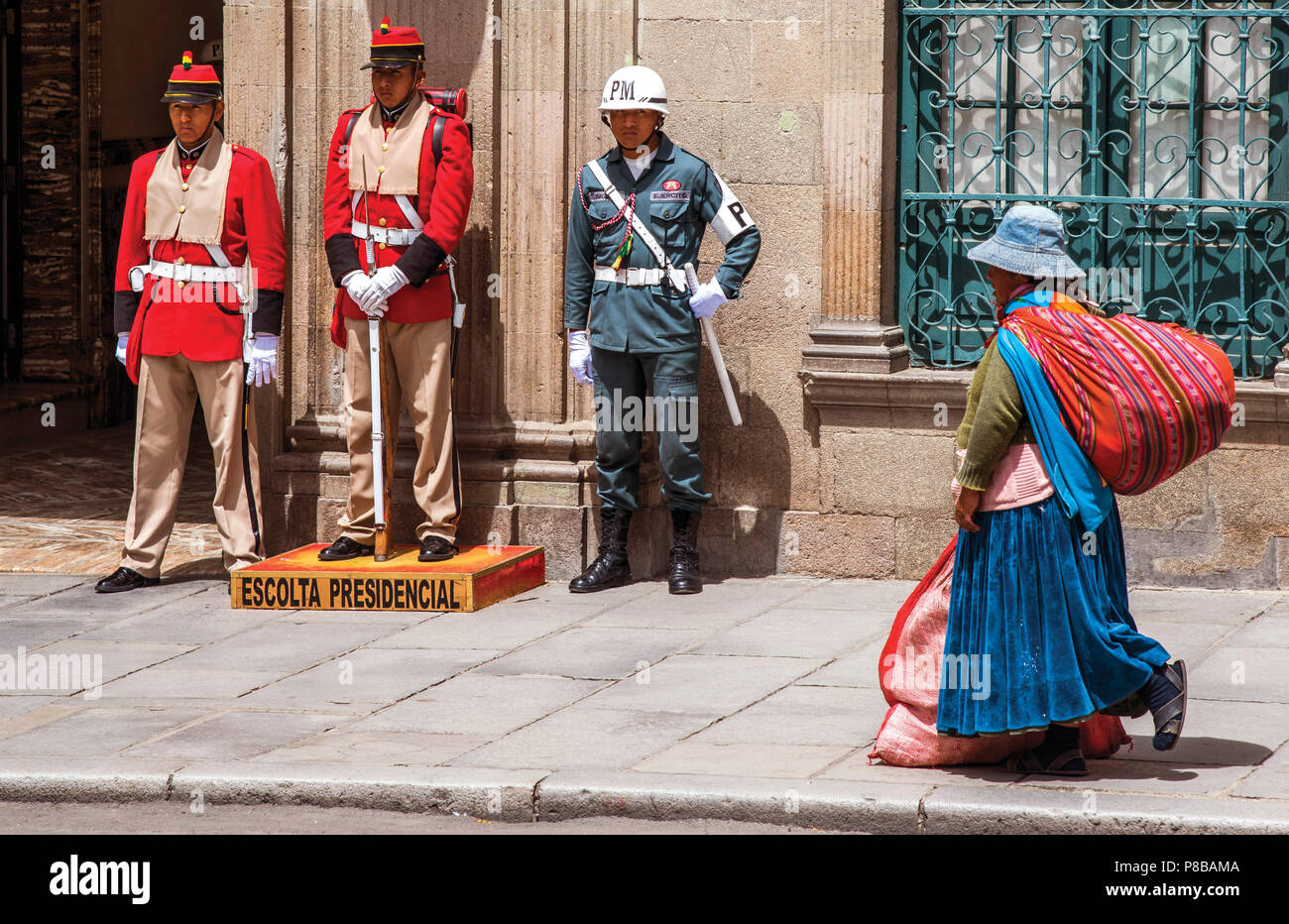 Militari che sorvegliano il palazzo presidenziale, Plaza Murillo, La Paz, Bolivia, come Quechua donna cammina passato Foto Stock