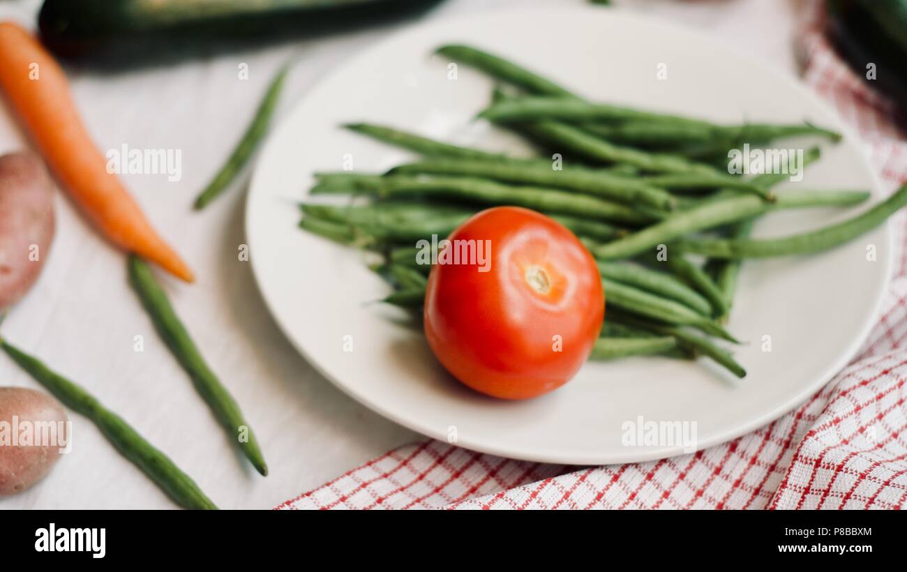 Flat-lay di materie di verdure di stagione su sfondo bianco. Mangiare sano concetto, vegetariane e vegane, pulire mangiare. Foto Stock