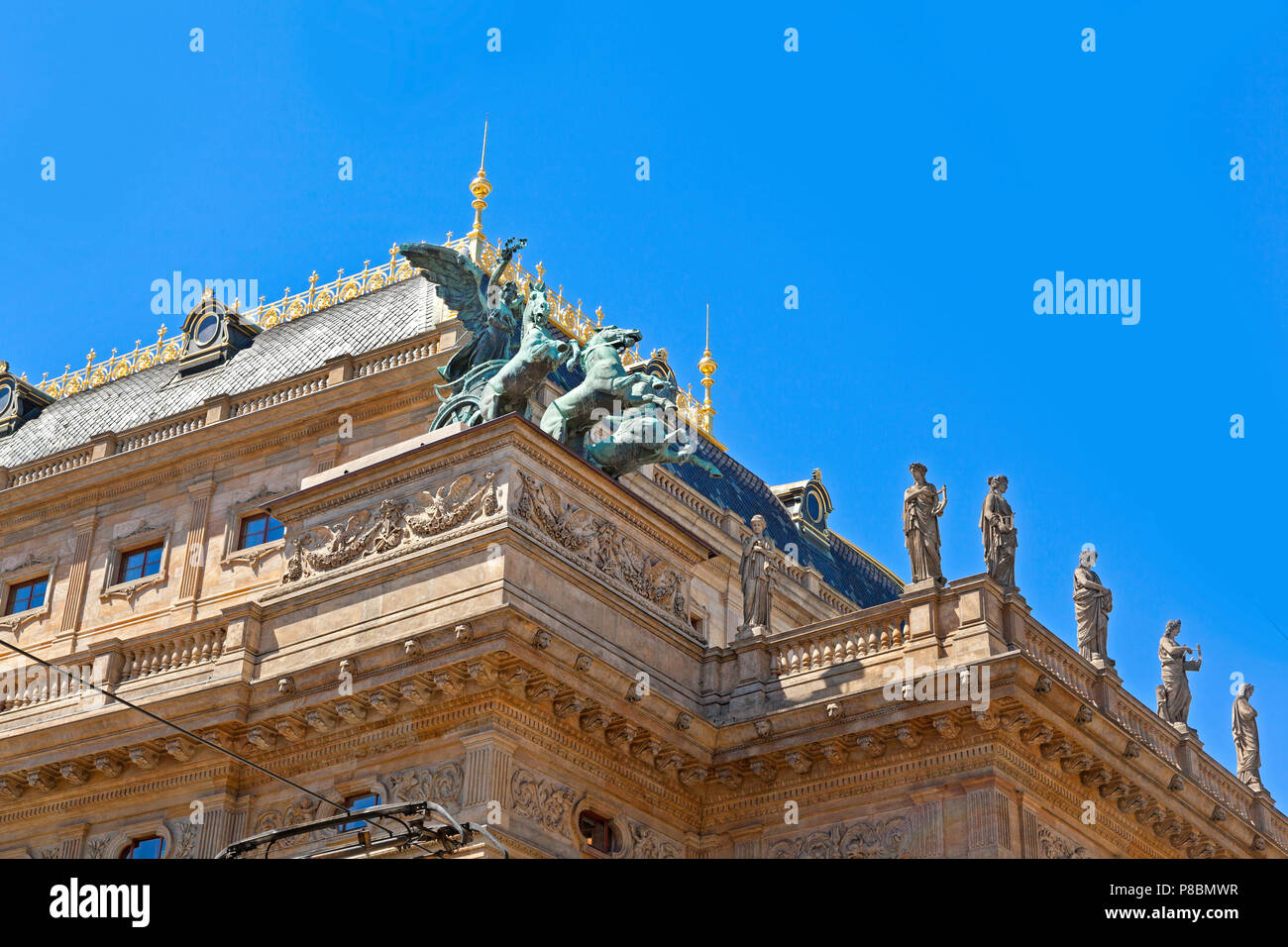 Teatro Nazionale, dettagli architettonici, statue, carri, sole luminoso cielo blu. Prague Old Town Repubblica Ceca Foto Stock