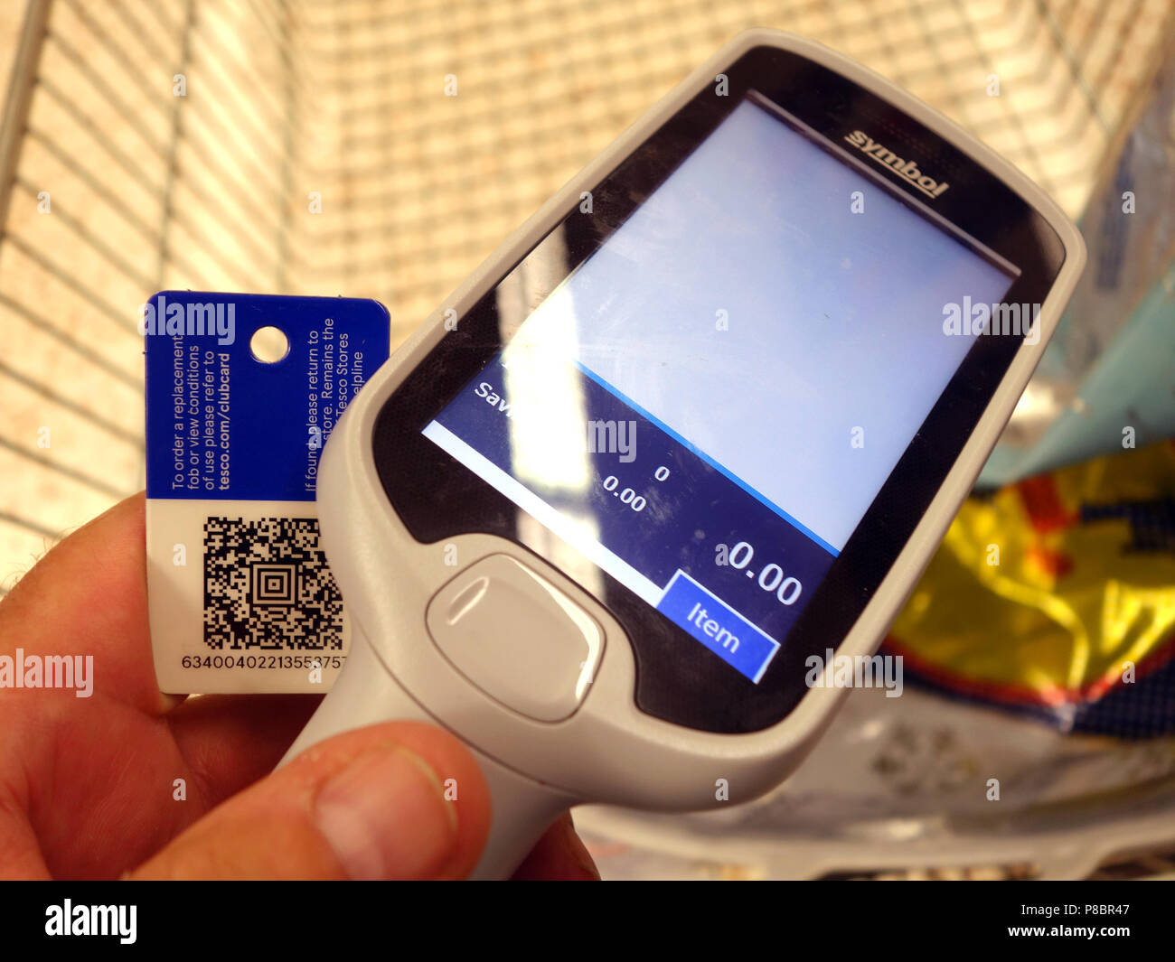 Uomo di iniziare il suo shopping a Tesco utilizzando la sua Clubcard Membership card per utilizzare la scansione come routine di negozio Foto Stock