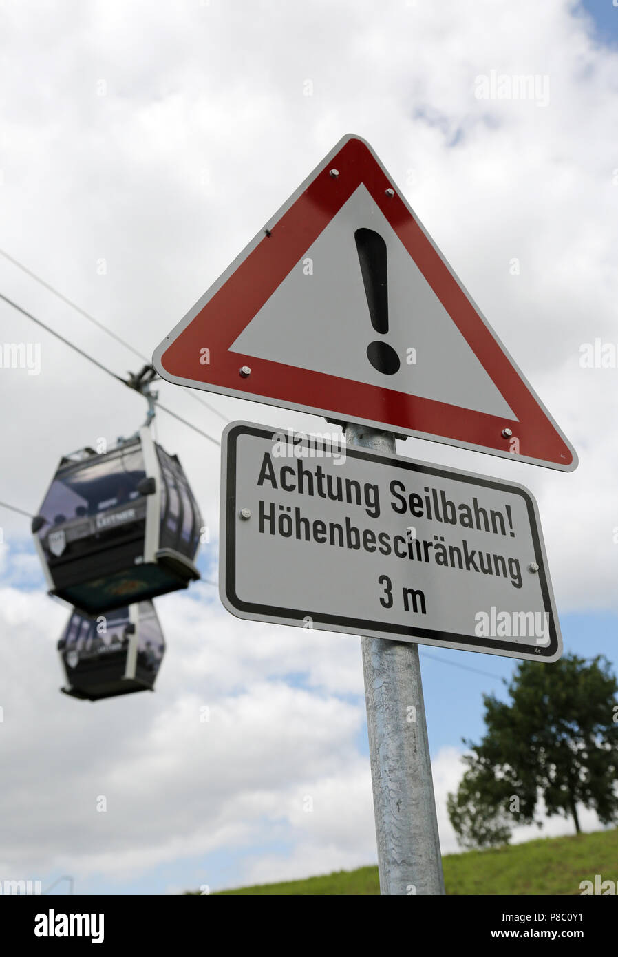 Berlino, Germania, segno - Attenzione la funivia - di fronte a due funivia gondole Foto Stock