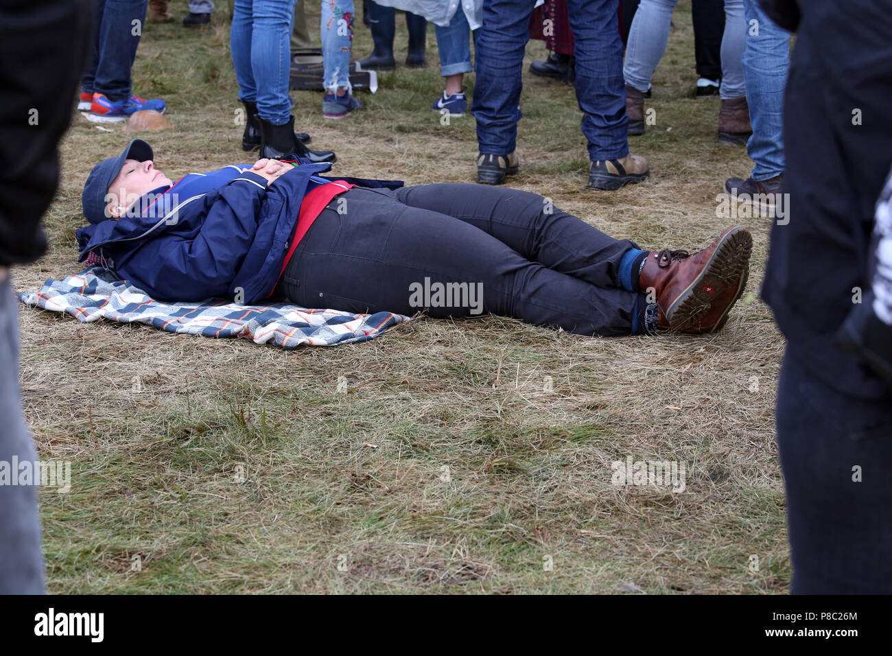 Hoppegarten, Germania, donna dorme in mezzo a una folla sul pavimento Foto Stock