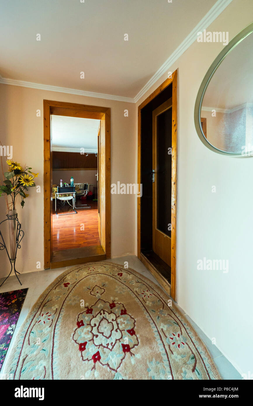 Una bella forma ovale tappeto giacente nella camera vicino alla porte di legno che portano nella stanza accanto. . Per il vostro design Foto Stock