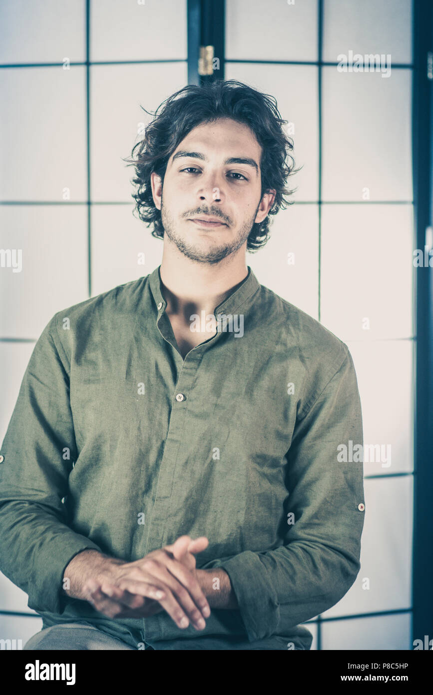 Ritratto di giovane uomo con le mani alzate al petto Foto Stock