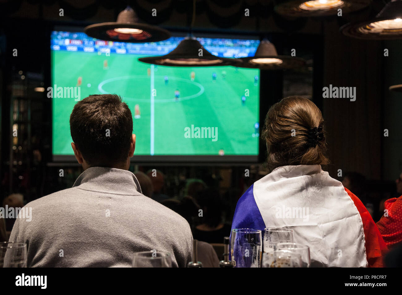 Immagine di un gruppo di sostenitori francesi in un ristorante a guardare su uno schermo gigante la semifinale partita Francia Belgio, durante il 2018 FIFA World Cup, che ha visto la vittoria del team francese. Il 2018 FIFA World Cup è il ventunesimo FIFA World Cup, un torneo internazionale di calcio contestato dagli uomini della squadre nazionali di associazioni membri della FIFA una volta ogni quattro anni. È attualmente in corso in Russia a partire dal 14 giugno e terminerà con la partita finale del 15 luglio 2018 Foto Stock