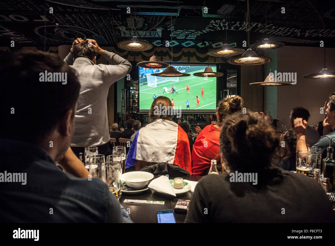 Immagine di un gruppo di sostenitori francesi in un ristorante a guardare su uno schermo gigante la semifinale partita Francia Belgio, durante il 2018 FIFA World Cup, che ha visto la vittoria del team francese. Il 2018 FIFA World Cup è il ventunesimo FIFA World Cup, un torneo internazionale di calcio contestato dagli uomini della squadre nazionali di associazioni membri della FIFA una volta ogni quattro anni. È attualmente in corso in Russia a partire dal 14 giugno e terminerà con la partita finale del 15 luglio 2018 Foto Stock