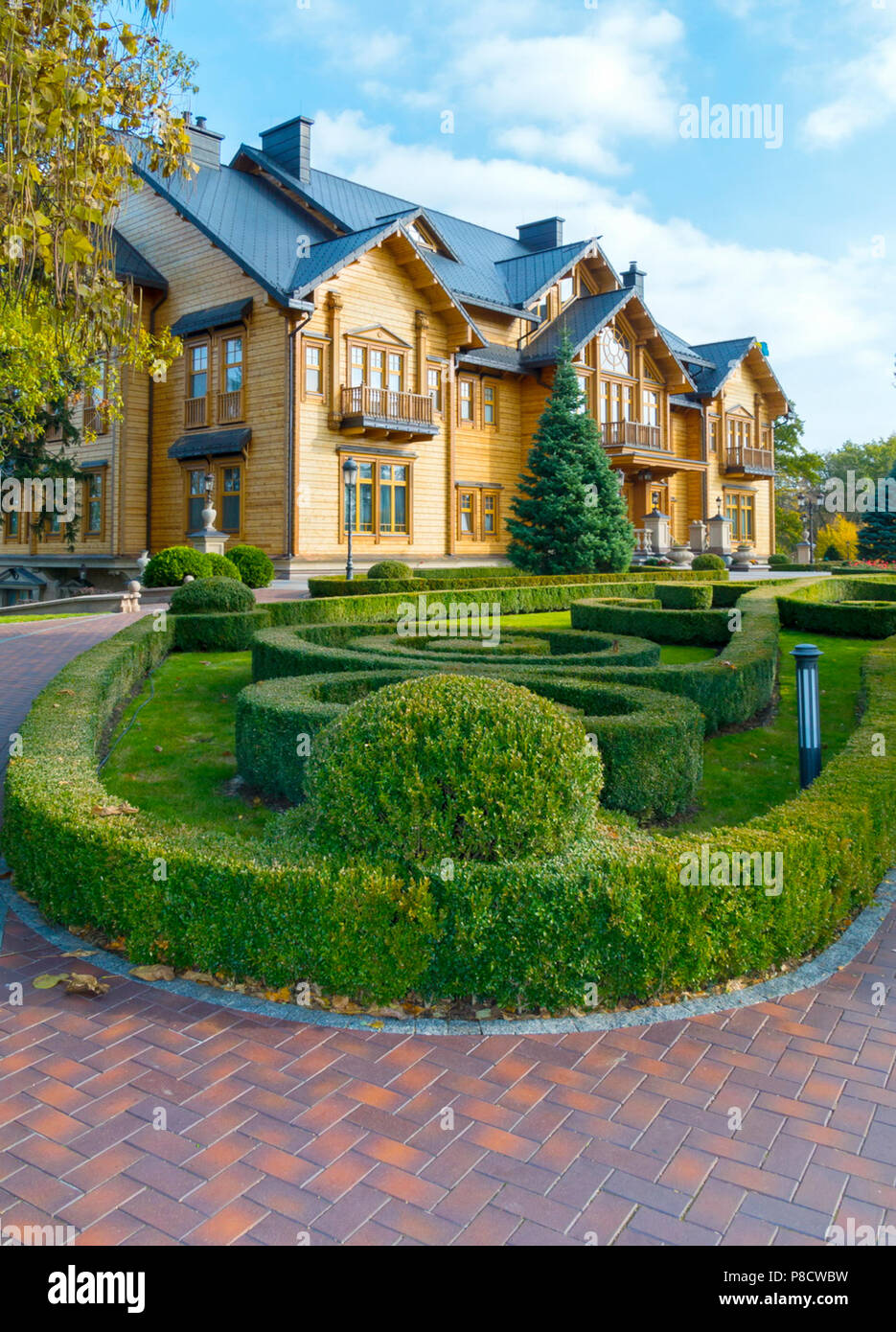 Un aiuola con un labirinto di cespugli verdi vicino all'elegante palazzina in legno . Per il vostro design Foto Stock