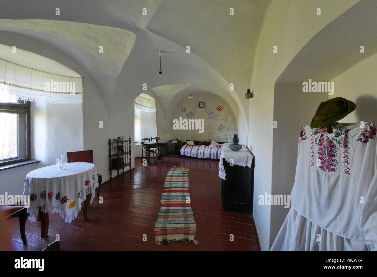 Installazione di una casa di villaggio con imbiancatura sulle pareti, ricamato con un asciugamano e tovaglie e pavimento in legno. Lampade a soffitto fuori di pl Foto Stock