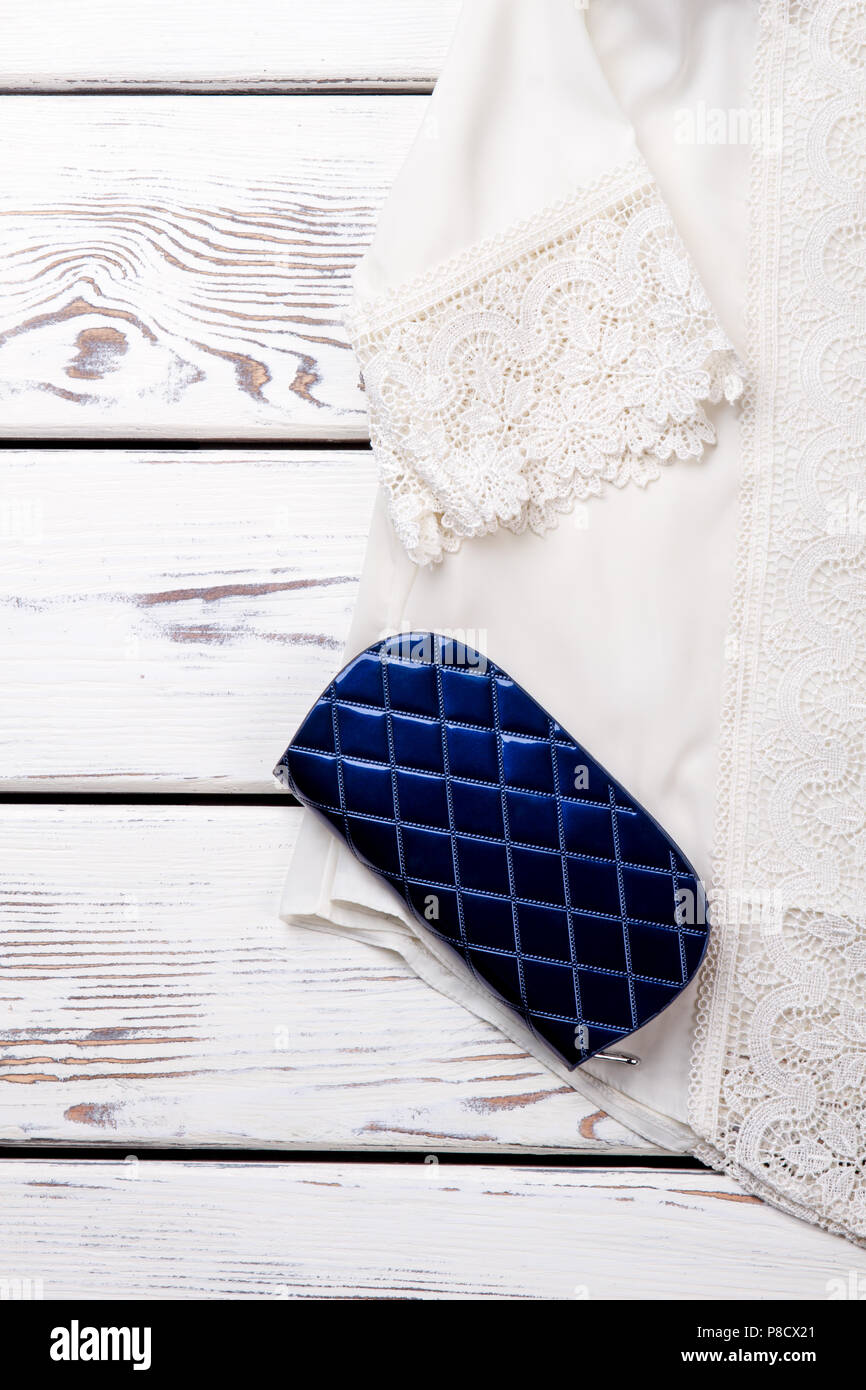 Bianco camicetta in pizzo e portafoglio blu. Foto Stock