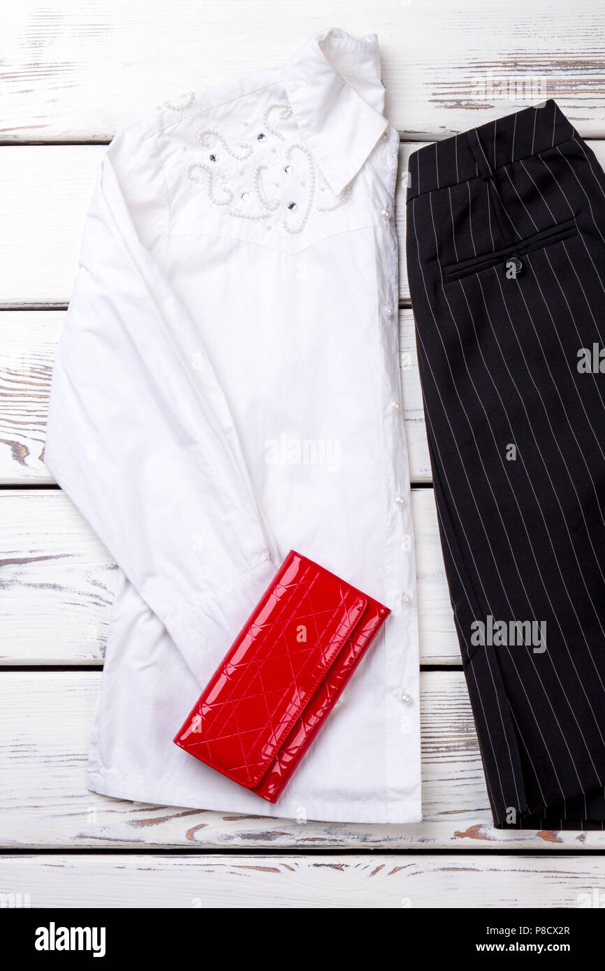 Ripiegata decorato bianco donna Blusa e red wallet. Foto Stock