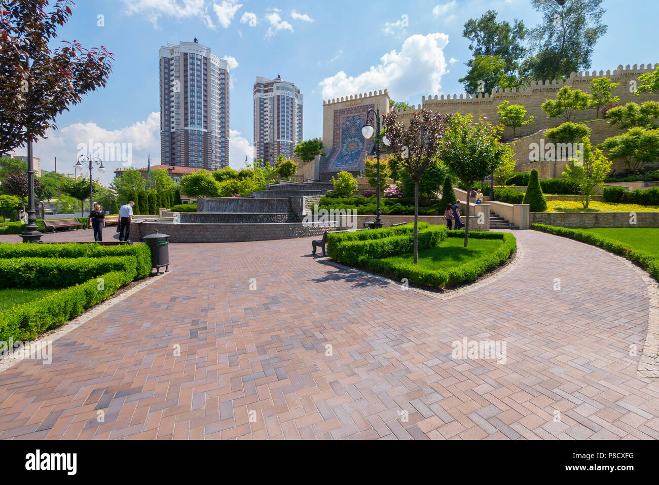 Una bella piazza con una grande fontana centrale e un muro storico sullo sfondo di alti edifici ad alta . Per il vostro design Foto Stock