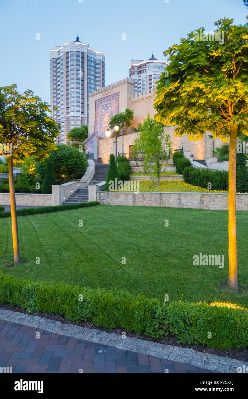 Grande Muro beige con un immagine ornamentali in medio sullo sfondo di un verde parco zona con arbusti e alberi . Per il vostro design Foto Stock