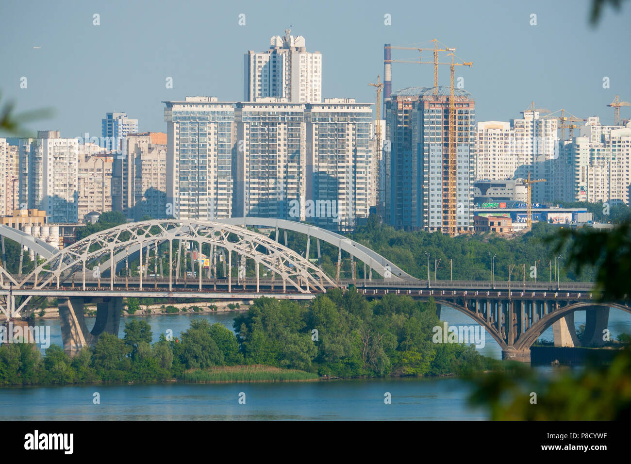 Un pittoresco ponte che attraversa il fiume contro lo sfondo di urbana moderna edifici ad alta . Per il vostro design Foto Stock