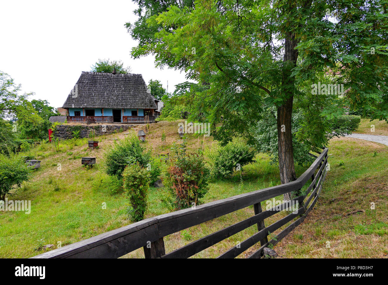 Una piccola casa privata su un terreno in pendenza con erba verde è  recintato da una tavola di legno, semplice recinzione . Per il vostro  design Foto stock - Alamy