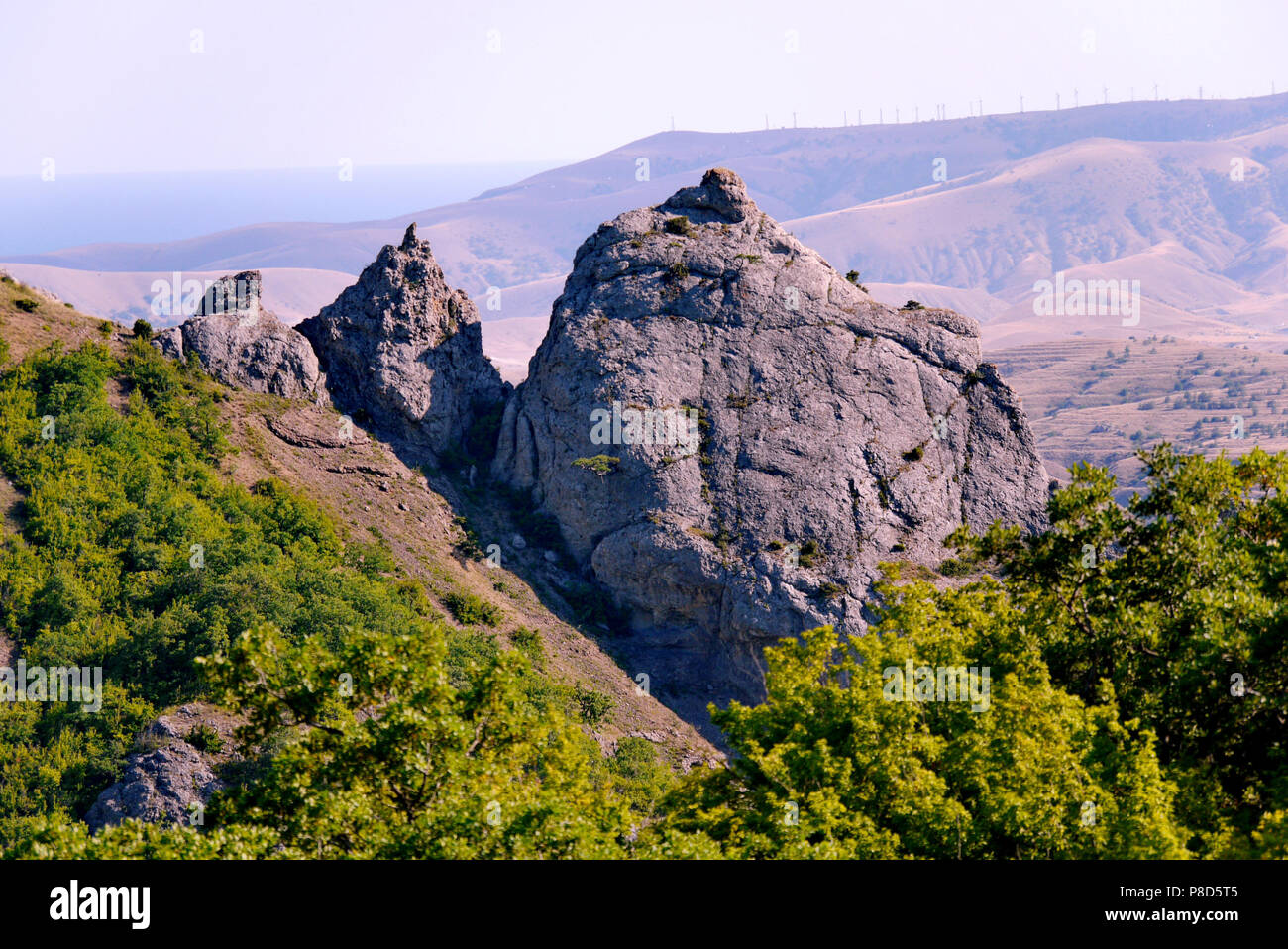 Tre alte rocce con spiers contro lo sfondo delle montagne e celeste. luoghi di estrema passeggiate . Per il vostro design Foto Stock