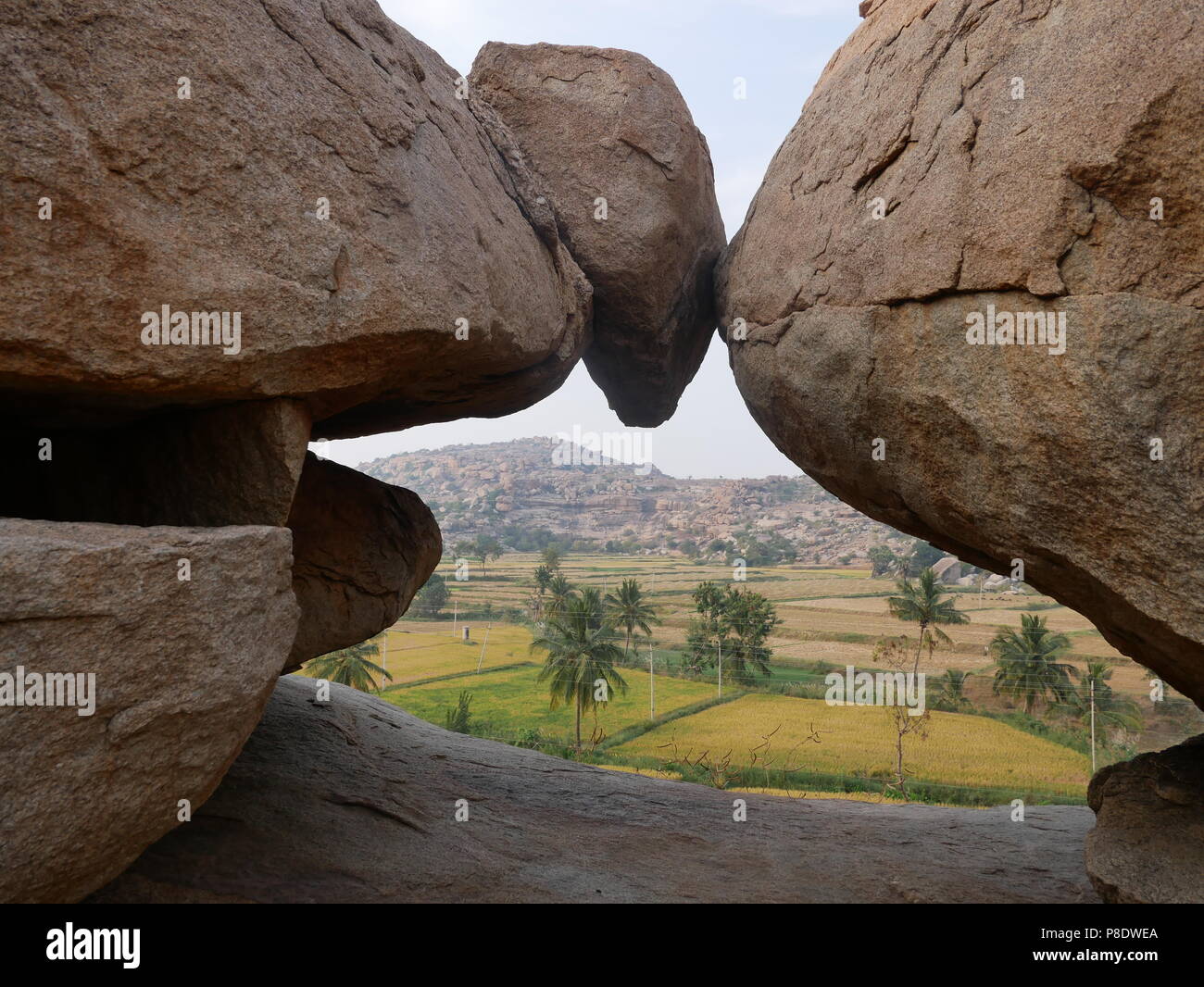 Risaie e giganteschi massi definiscono il paesaggio unico di Hampi ex capitale dell'antico Impero Vijaynagra in India è stato Karnataka. Foto Stock