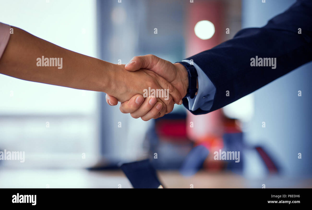 Business Partner per lo handshaking. Vista ravvicinata della donna e uomo stringono le mani. Tonica concetto. Foto Stock