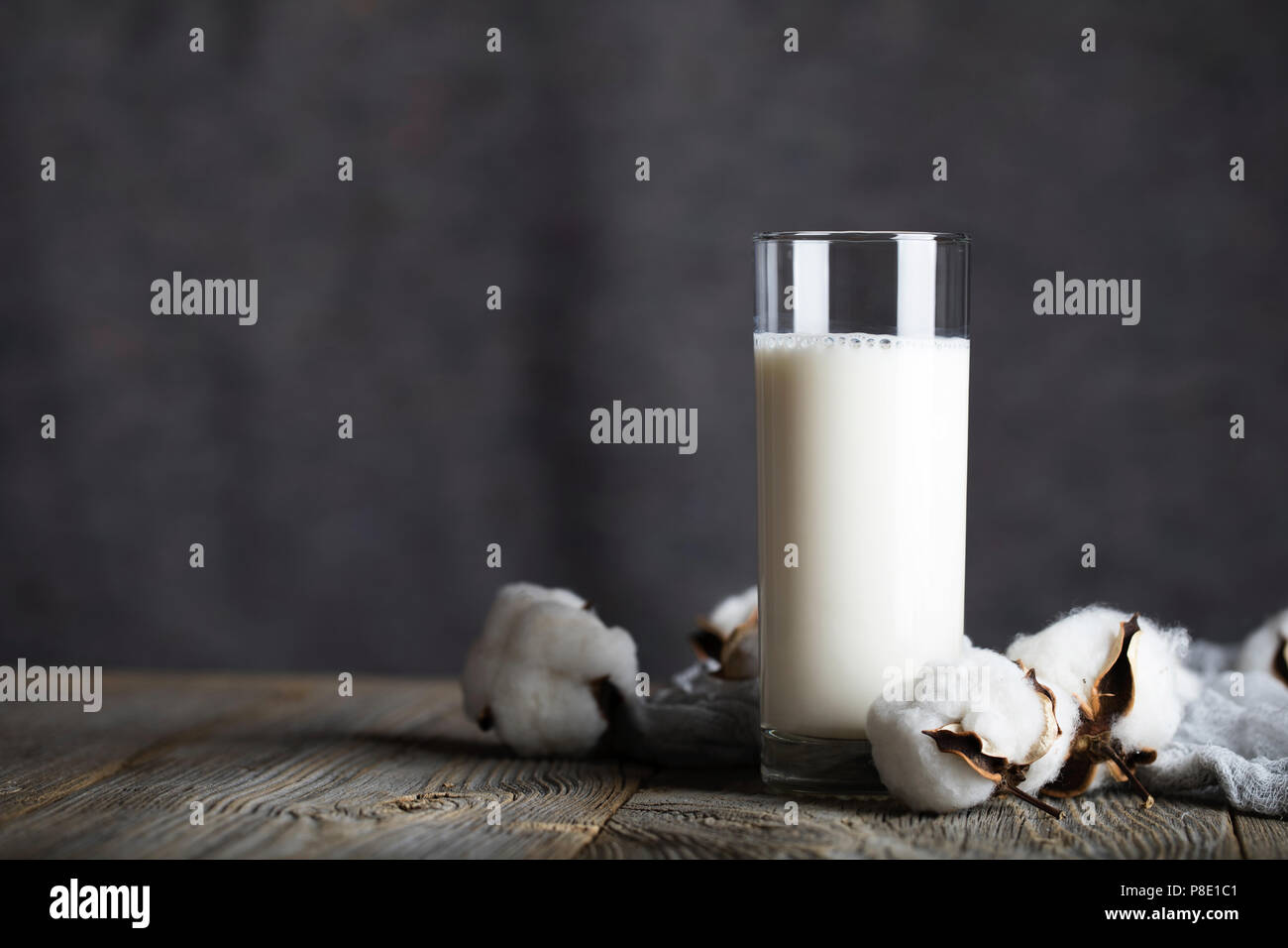 Bicchiere di latte burro e pianta di cotone bolls. Primo piano Foto Stock