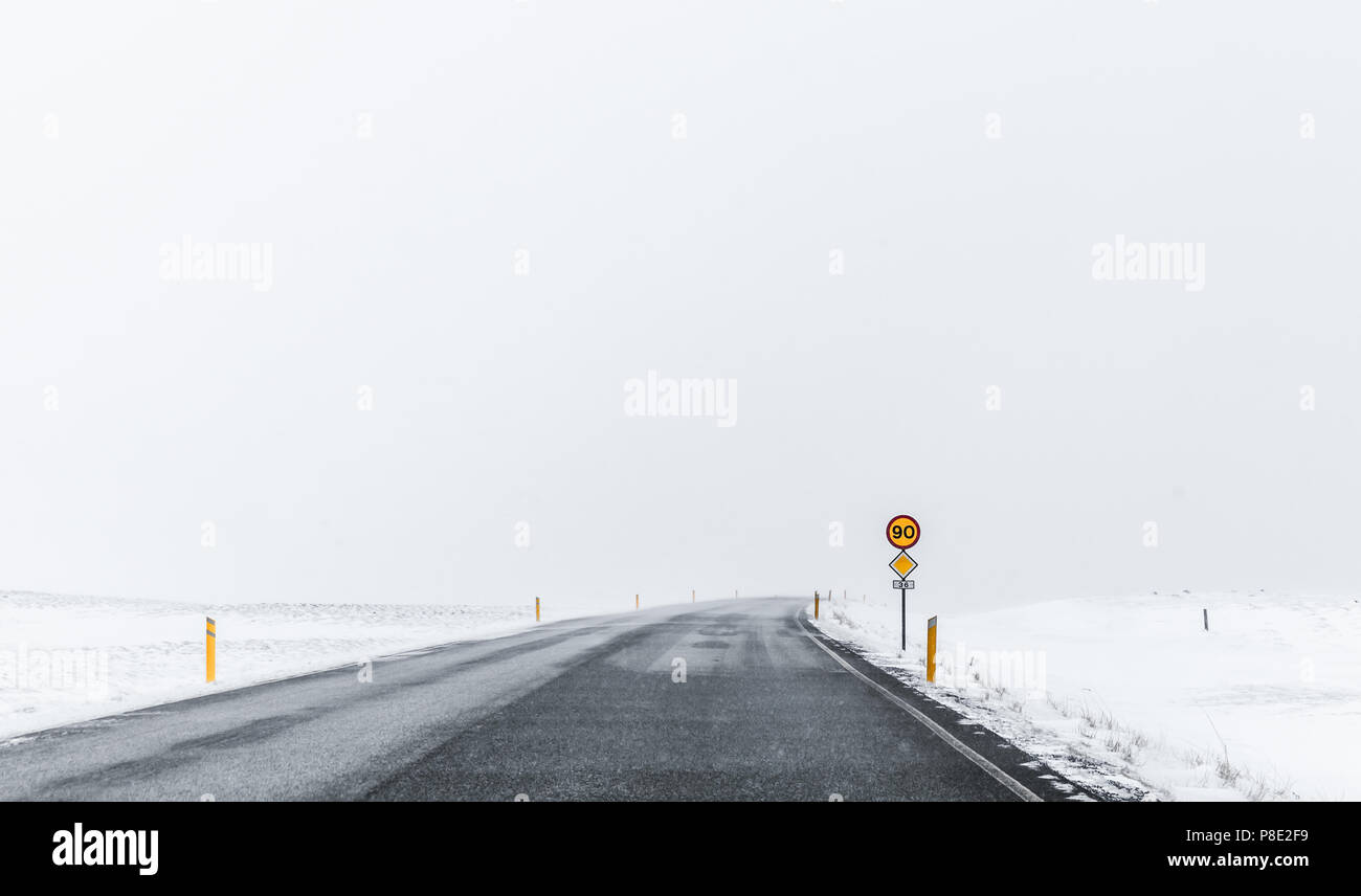Congelati strada coperta di neve nel ventoso giorno d'inverno. Distretto di Reykjavik, Islanda Foto Stock