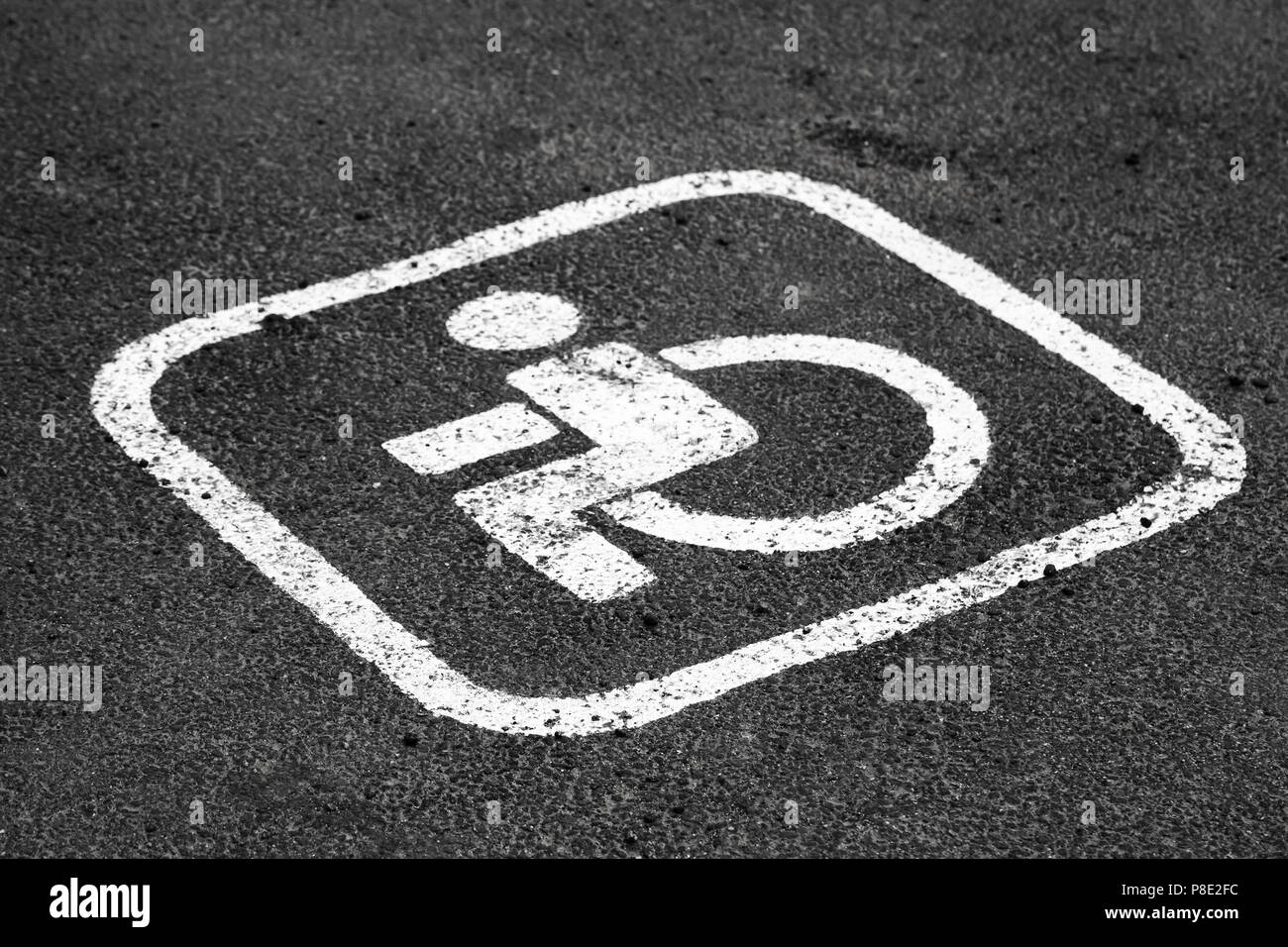 Posto per persone disabili auto su un lotto di parcheggio di strada bianca la marcatura su asfalto scuro. Close-up foto con messa a fuoco selettiva Foto Stock
