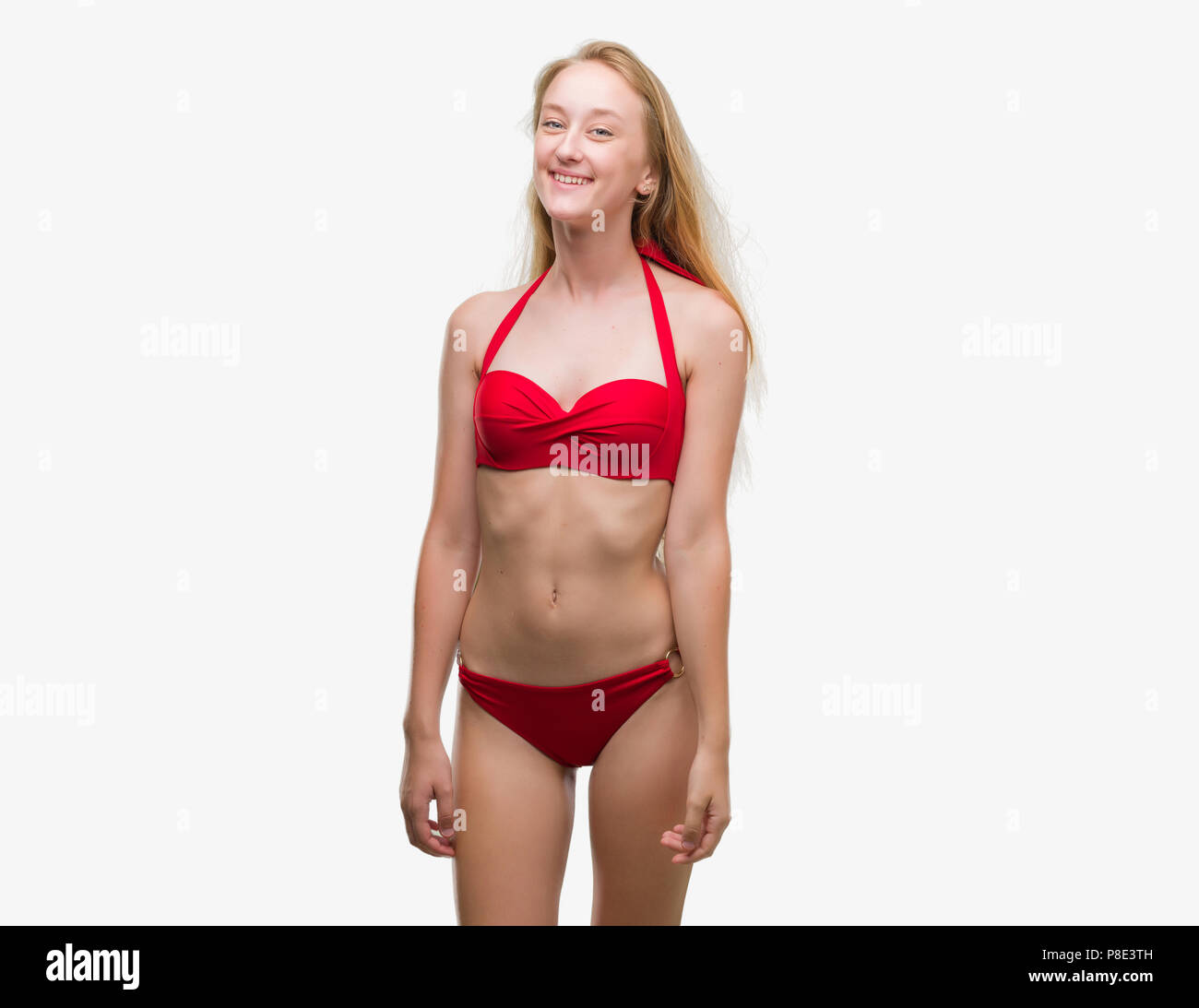 Adolescente bionda donna che indossa un bikini rosso con una felice e fresco sorriso sul viso. Persona fortunata. Foto Stock