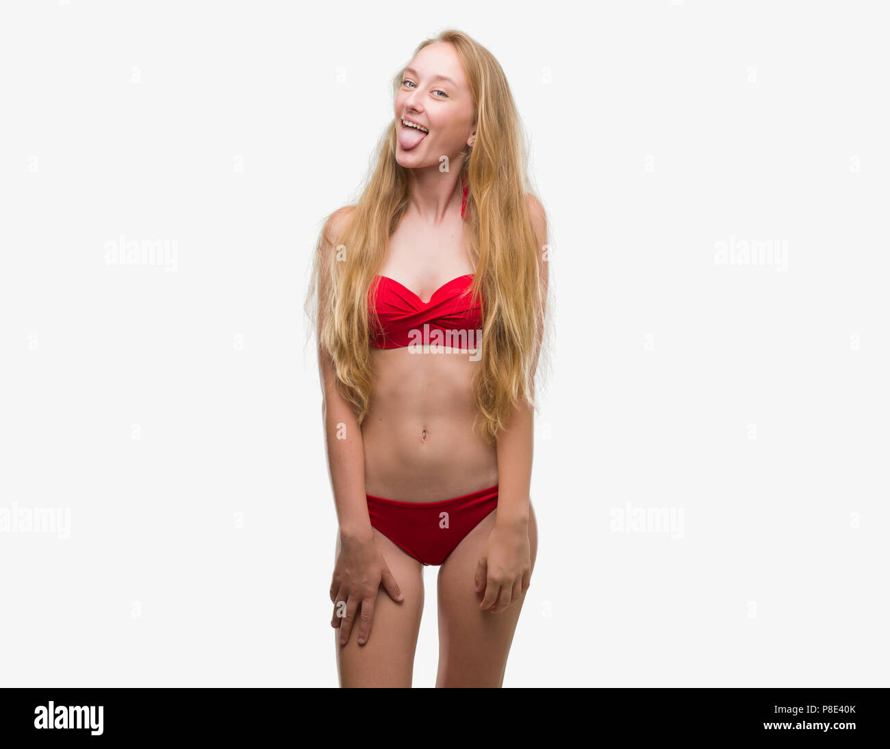 Adolescente bionda donna che indossa un bikini rosso con la lingua fuori  con felice espressione divertente. Concetto di emozione Foto stock - Alamy