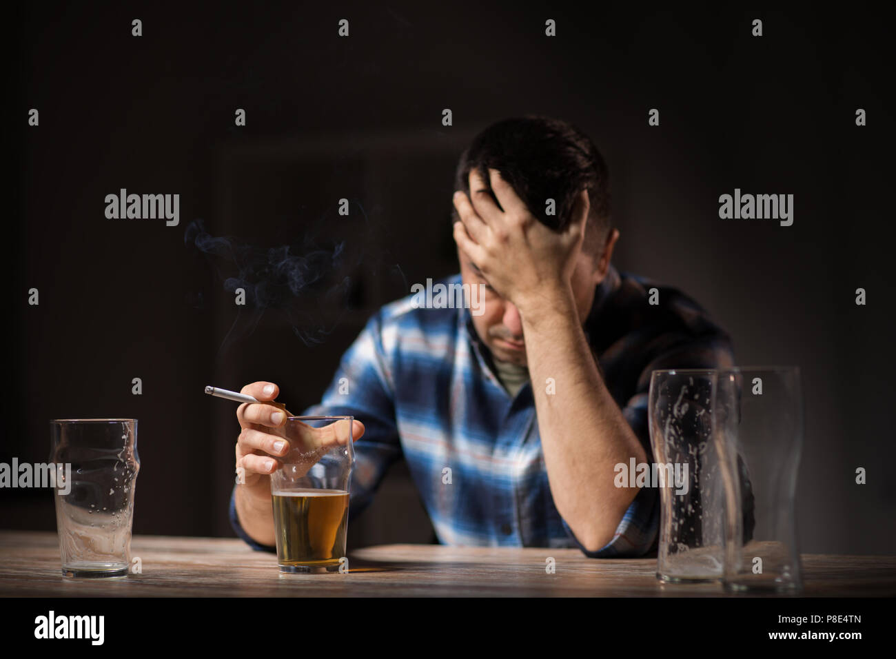 Uomo ubriaco bere alcolici e fumare sigaretta Foto Stock