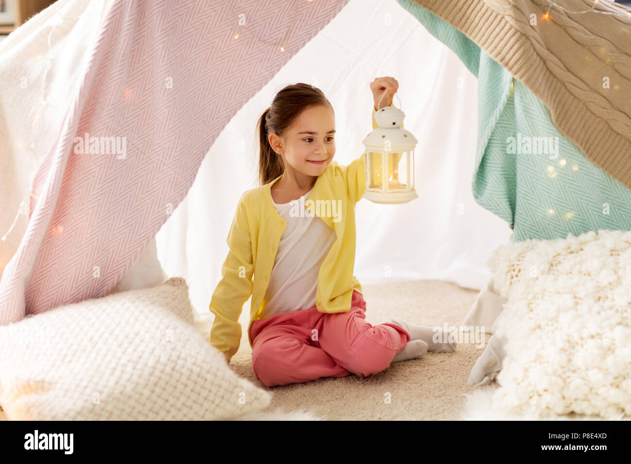 Bambina con lanterna in kids tenda a casa Foto Stock