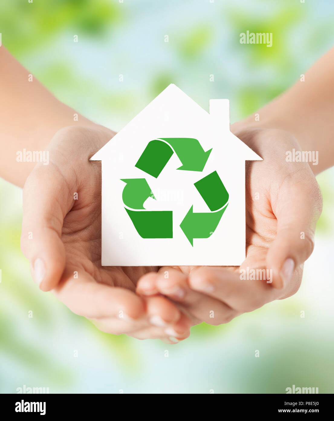Mani casa verde con il segno di riciclaggio Foto Stock