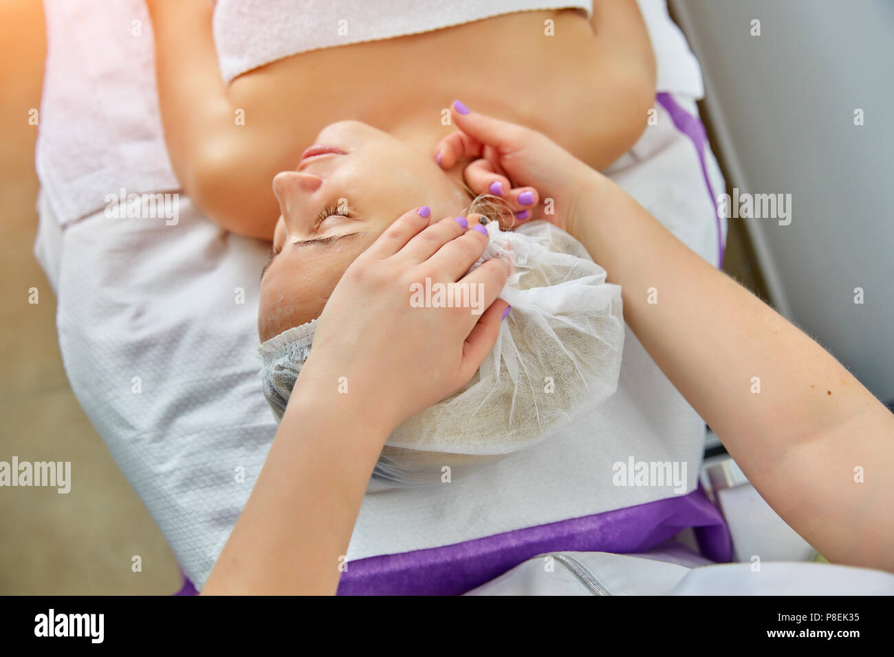 Bucce di facciali nel beauty spa salone. Maschera con scrub per il ringiovanimento faccia di pelle. Felice e rilassato donna di mezza età. Il massaggio del viso Foto Stock