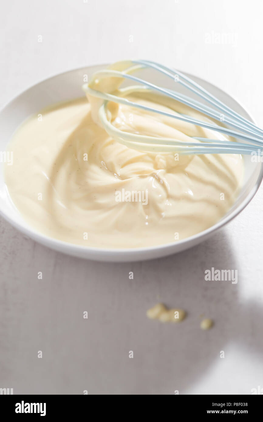 Ciotola Di Crema Alla Vaniglia Con Frusta Blu Foto Stock Alamy