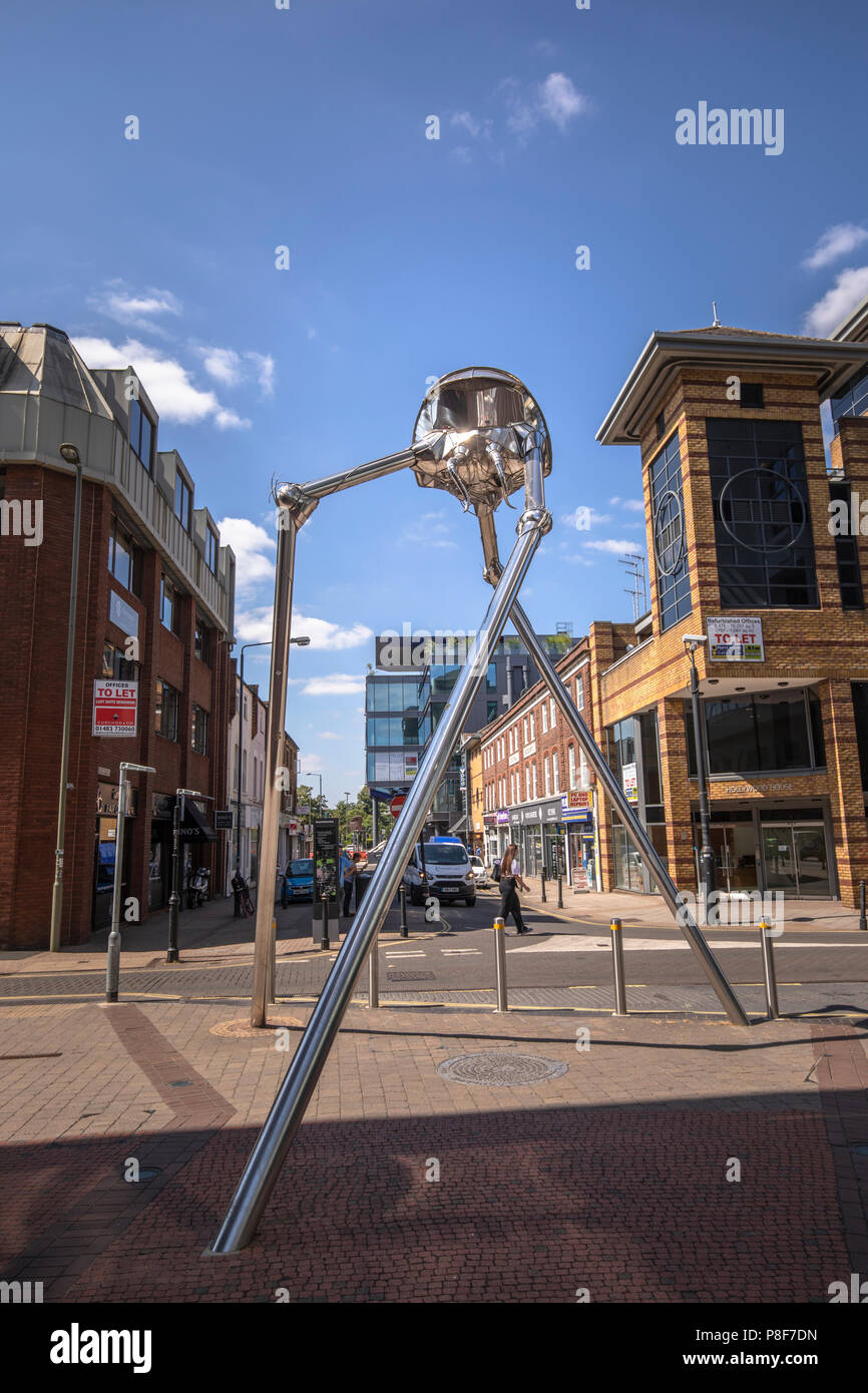 Scultura metallica nella piazza di corona di un treppiede marziano invasore da H G Wells' classico romanzo la guerra dei mondi, che è impostato a Woking, Surrey, Regno Unito Foto Stock