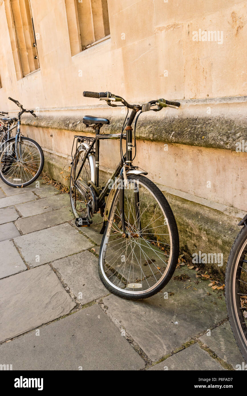 Bicicletta con una ruota piegata che giace contro un muro nel centro di Oxford Foto Stock