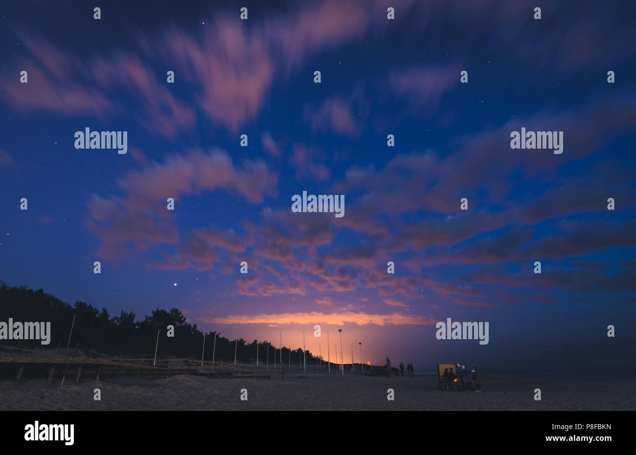 Tranquille vedute del molo del Mar Baltico durante l'alba, il tramonto e la notte con luci accese, cieli colorati e lunghi riflessi di esposizione dalla Lituania Foto Stock